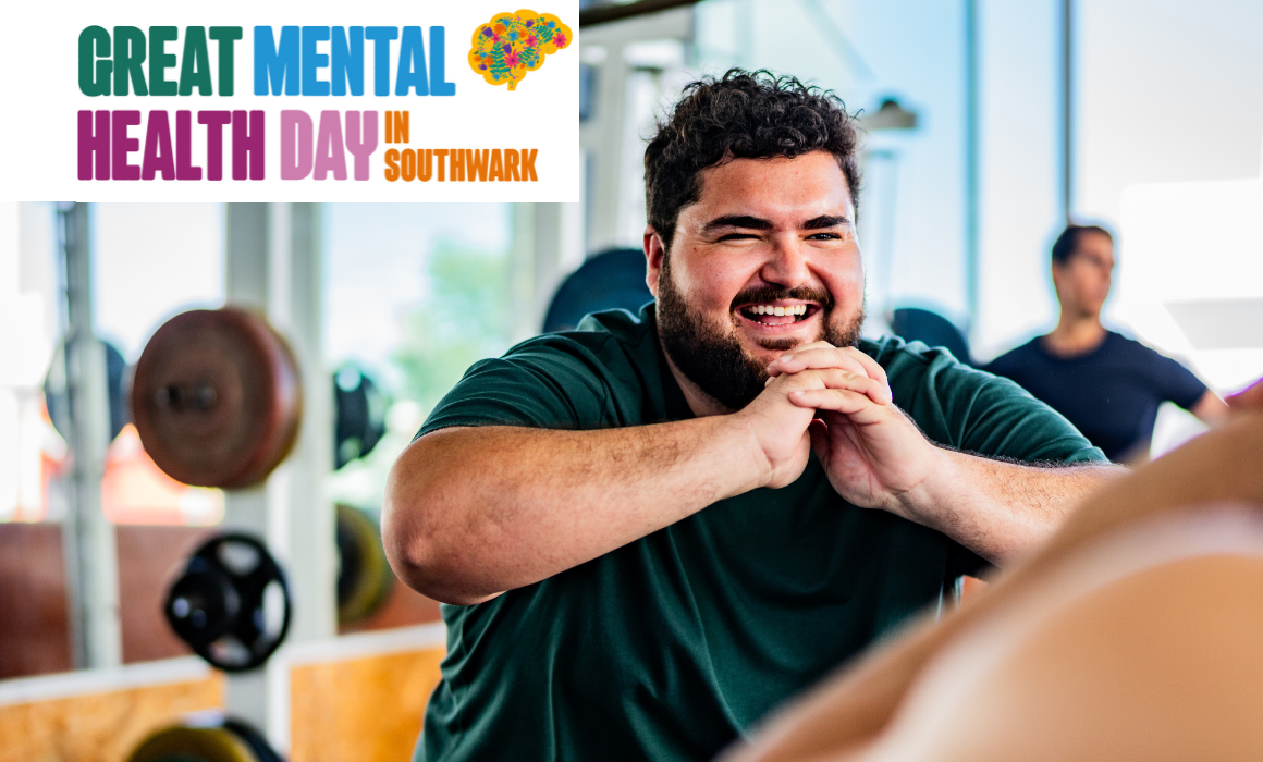 Image of man in gym smiling doing a squat